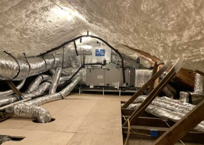Technician installing spray foam on the roof deck to create a closed attic in Austin. Attic Insulation