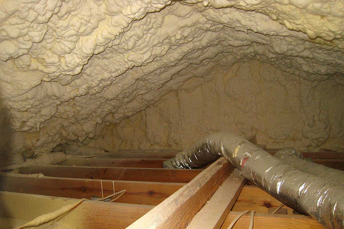 attic-encapsulation-05 Technician applying spray foam to the roof deck for a closed attic retrofit in Austin. Unvented attic Austin